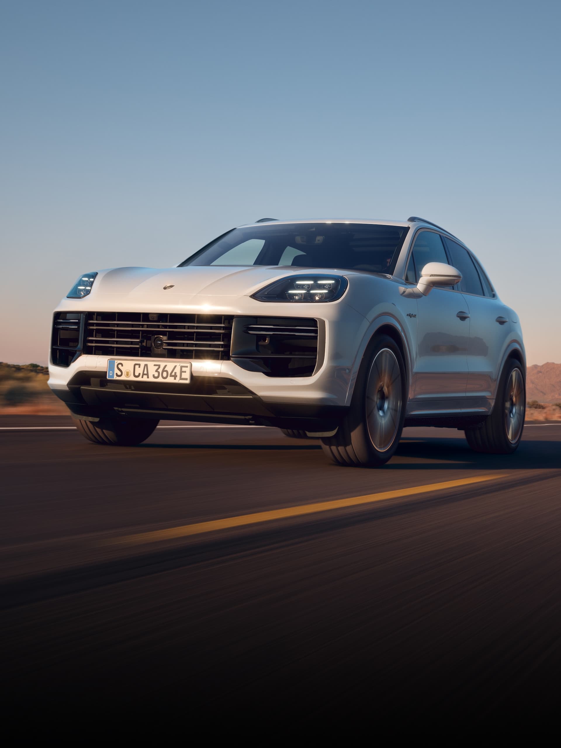 A Porsche Cayenne driving on an open road.